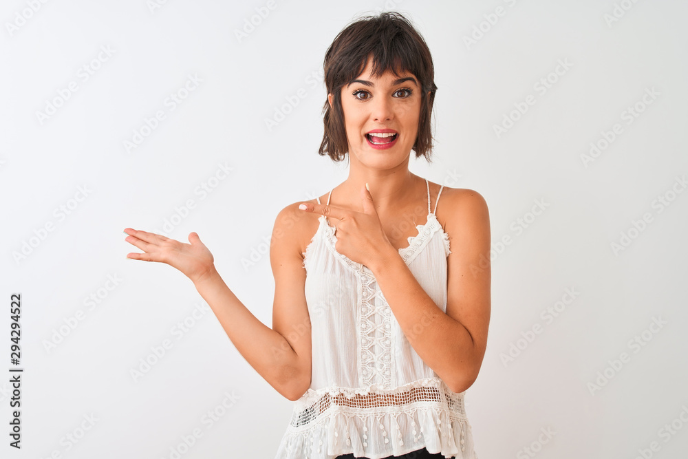 Young beautiful woman wearing summer casual t-shirt standing over isolated white background amazed and smiling to the camera while presenting with hand and pointing with finger. Young beautiful woman wearing summer casual t-shirt standing over isolated white background amazed and smiling to the camera while presenting with hand and pointing with finger.