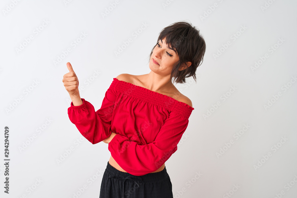 Young beautiful woman wearing red summer t-shirt standing over isolated white background Looking proud, smiling doing thumbs up gesture to the side Young beautiful woman wearing red summer t-shirt standing over isolated white background Looking proud, smiling doing thumbs up gesture to the side