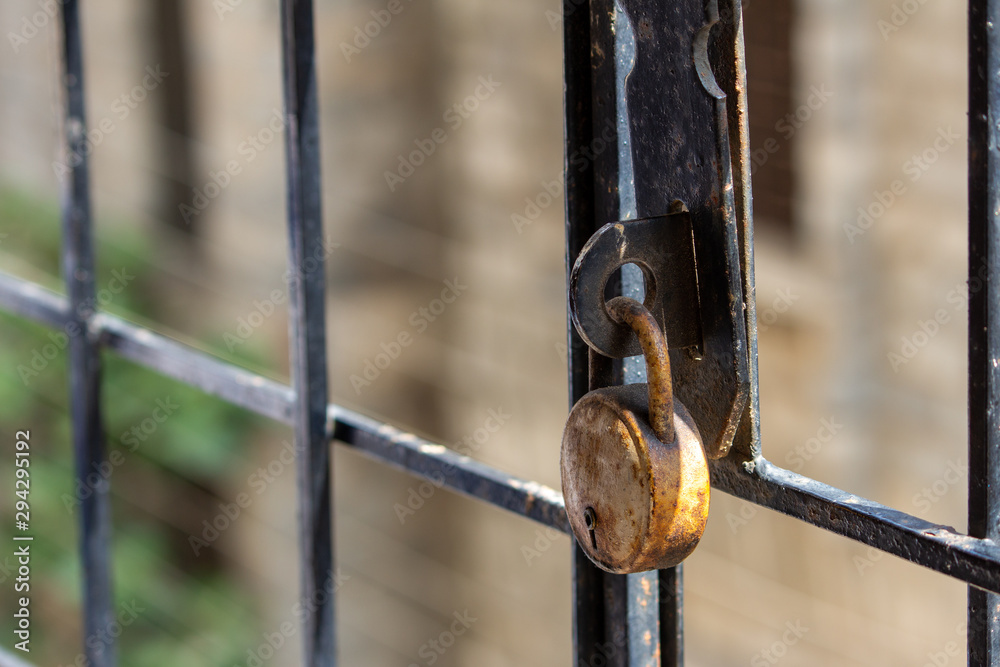 Rusted old lock on a iron grill for safety Rusted old lock on a iron grill for safety