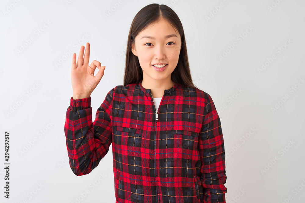 Young chinese woman wearing casual jacket standing over isolated white background smiling positive doing ok sign with hand and fingers. Successful expression. Young chinese woman wearing casual jacket standing over isolated white background smiling positive doing ok sign with hand and fingers. Successful expression.