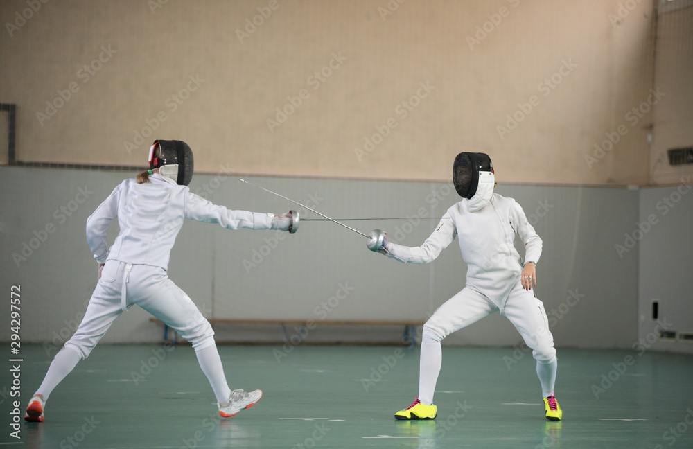 Two young women fencers having a training at the gym Two young women fencers having a training at the gym