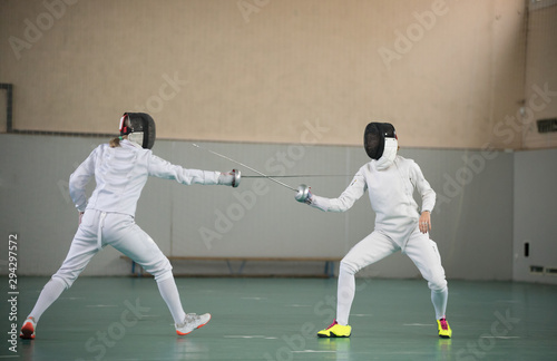 Two young women fencers having a training at the gym