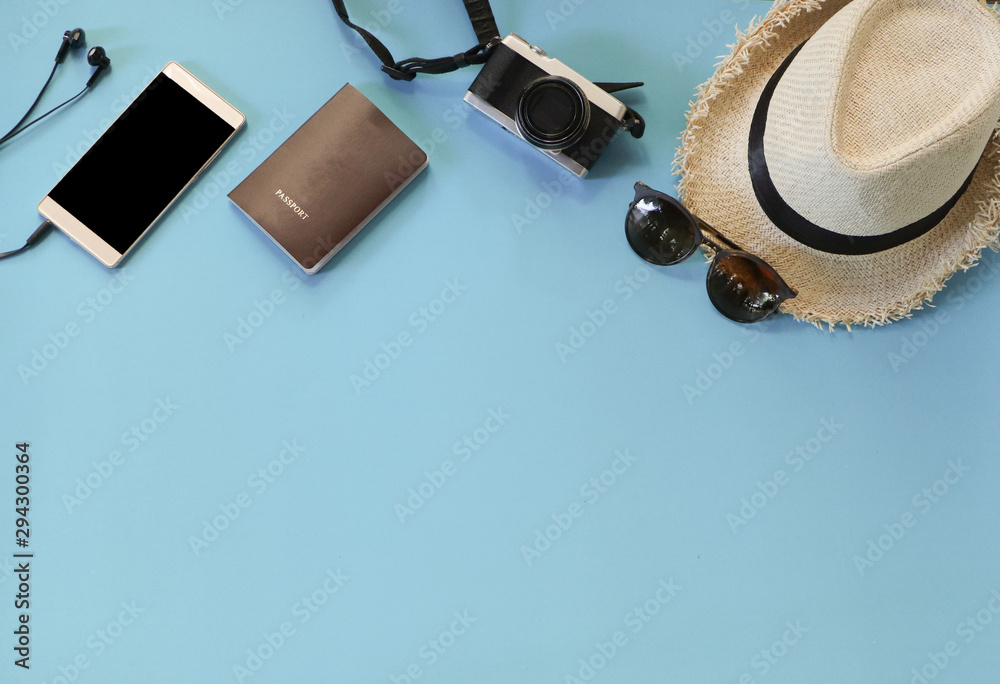 Travel concept . Top view of tourist accessories  on blue  background camera ,hat ,passport, mobile phone,sunglasses. - obrazy, fototapety, plakaty 