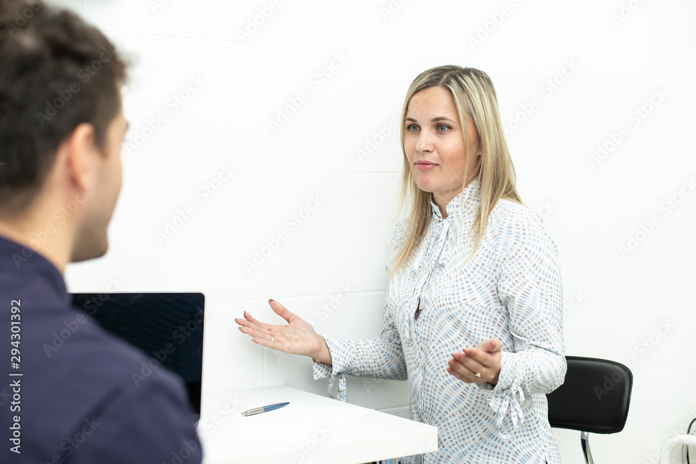 Handsom man talking with blond woman in dentist cabinet Handsom man talking with blond woman in dentist cabinet