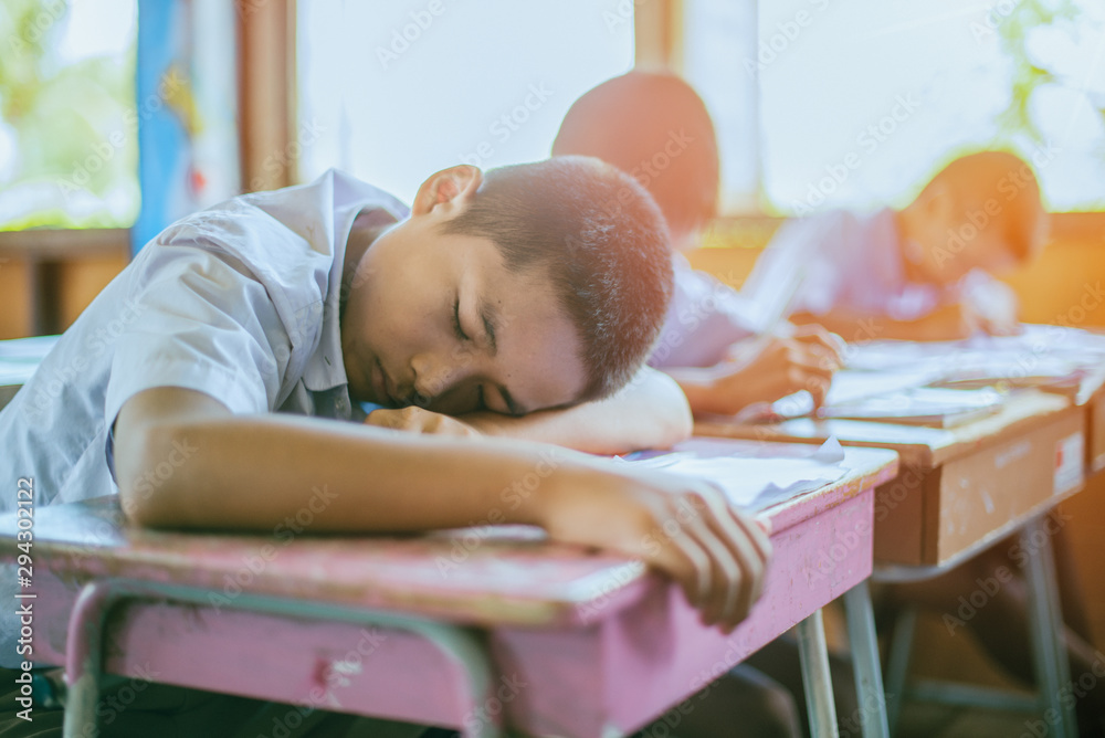 Students are sleeping on the desk in the classroom - obrazy, fototapety, plakaty 