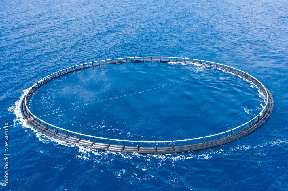 Aerial view close up, fish farm with floating cages in sea Stock Photo