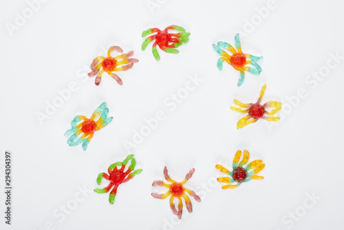 top view of colorful gummy spiders in circle isolated on white with copy space  Halloween treat
