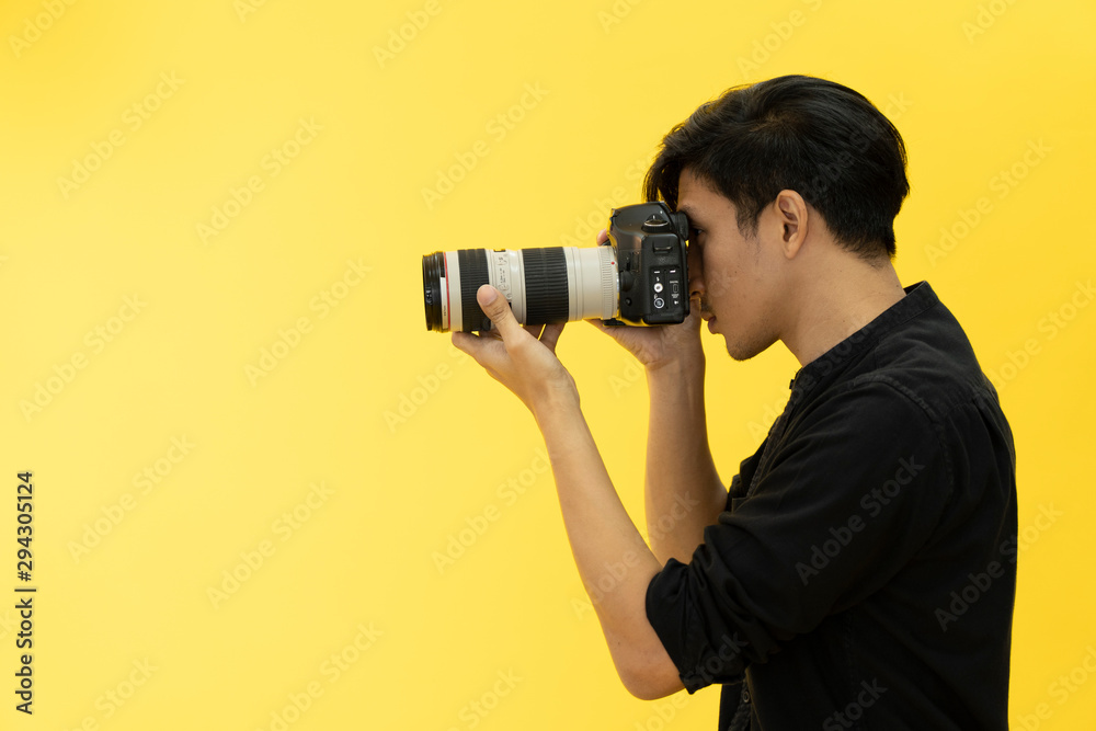 Obraz premium Young Professional photographer with camera in on photo studio background.