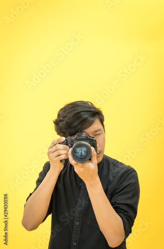 Young  Professional photographer with camera in on photo studio background.
