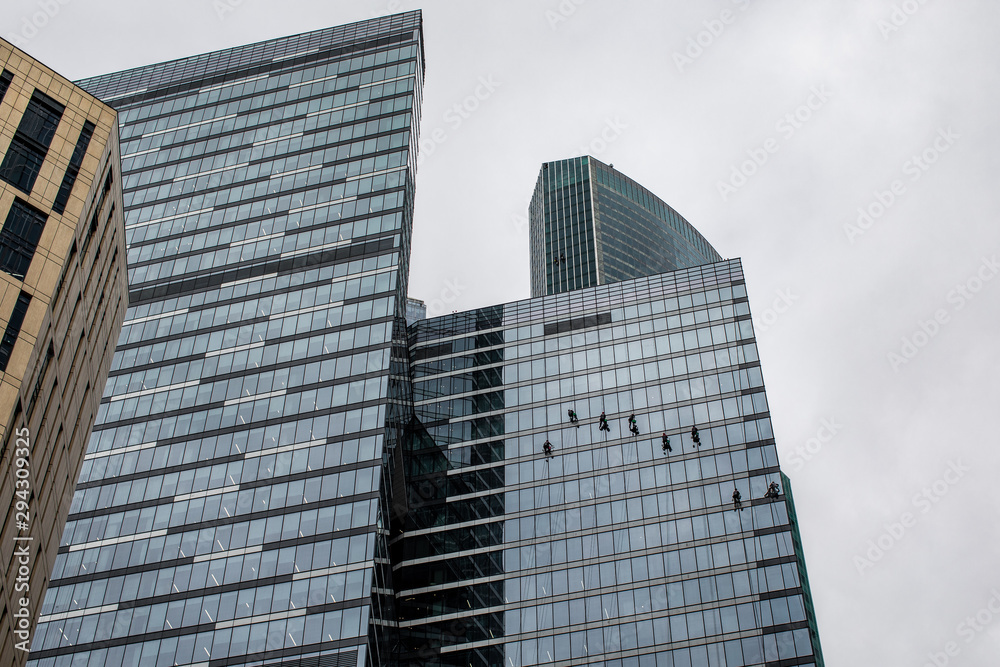 group of workers cleaning windows service on high rise building