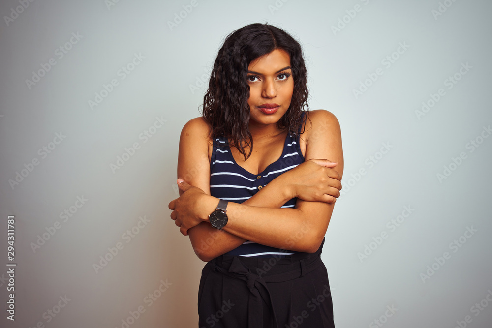 Obraz premium Transsexual transgender woman wearing striped t-shirt over isolated white background shaking and freezing for winter cold with sad and shock expression on face