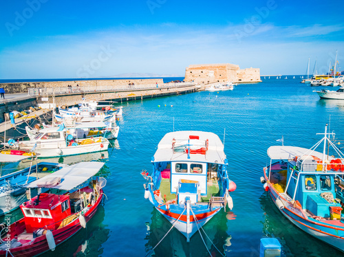 Heraklion, Crete beautiful view to harbor. Heraklion Koule, fortress. Blue sky and turquoise sea at the port of Heraklion city. Colorful boats in Greek port. Travel and places.