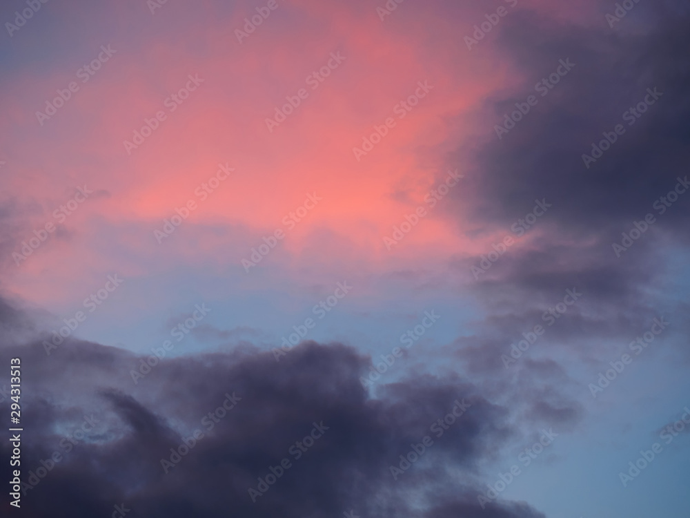 Dark gray and red clouds on a blue sky background