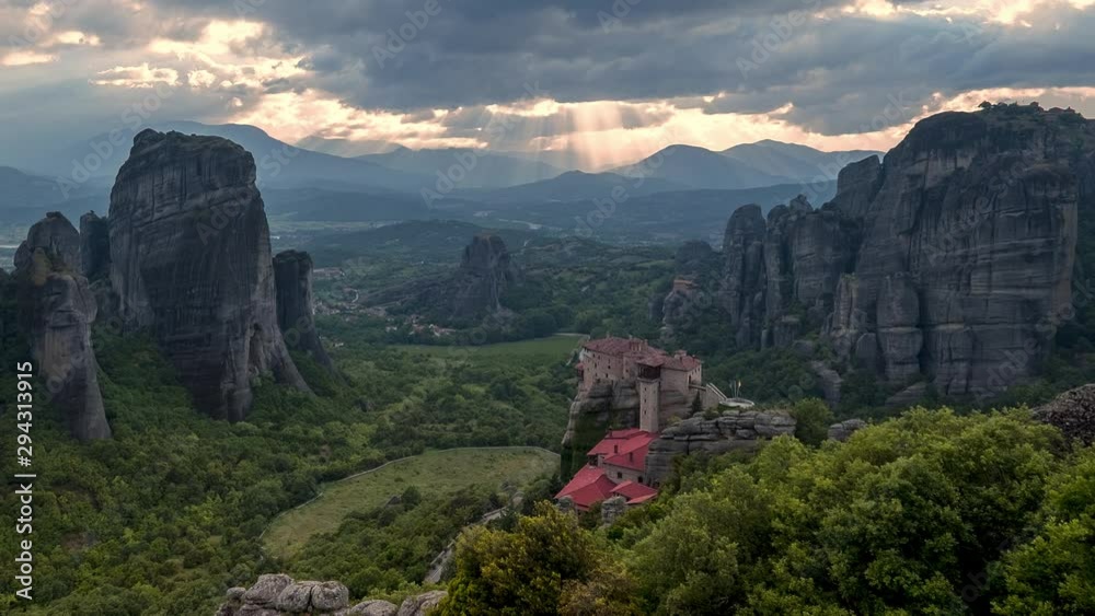 Breathtaking view of Varlaam monastery and Monastery of Rousanou. Sunbeams shining on iconic green valley from heaven. Amazing Meteora surrounded by high rocks. Holy landmark in Greece. Time lapse Breathtaking view of Varlaam monastery and Monastery of Rousanou. Sunbeams shining on iconic green valley from heaven. Amazing Meteora surrounded by high rocks. Holy landmark in Greece. Time lapse