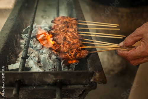 Satay or Sate being grilled on hawker street food market photo