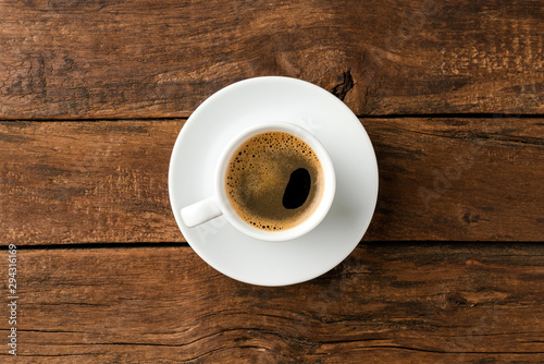 Overhead shot of hot coffee cup on wooden background with copyspace