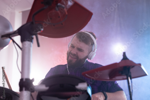 Hobbies, music and people concept - emotional man playing drums