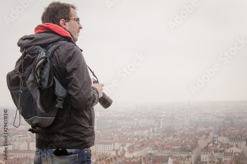 Un photographe regardant une ville. Un photographe regardant le panorama de la ville de Lyon. Un touriste photographe.