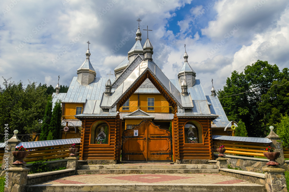 Verkhovyna, Ukraine. Beautiful wooden orthodox church on a background of summer cloudy sky.