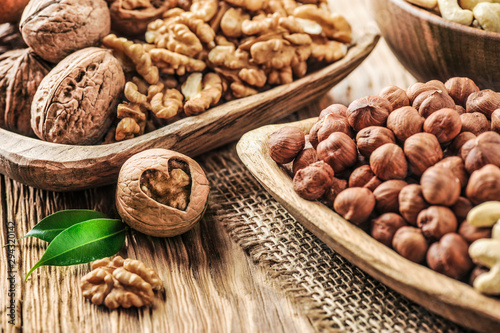 Mix nuts on wooden table. Nuts with walnut heart. Fresh raw nuts in bowls.