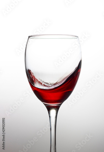 Splash of red wine in a crystal glass on a white background close-up