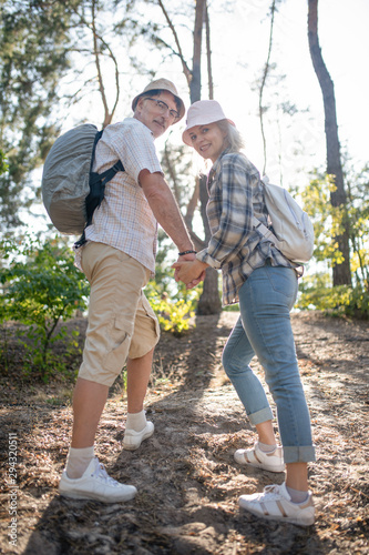 Couple wearing sneakers hiking in forest on nice warm day