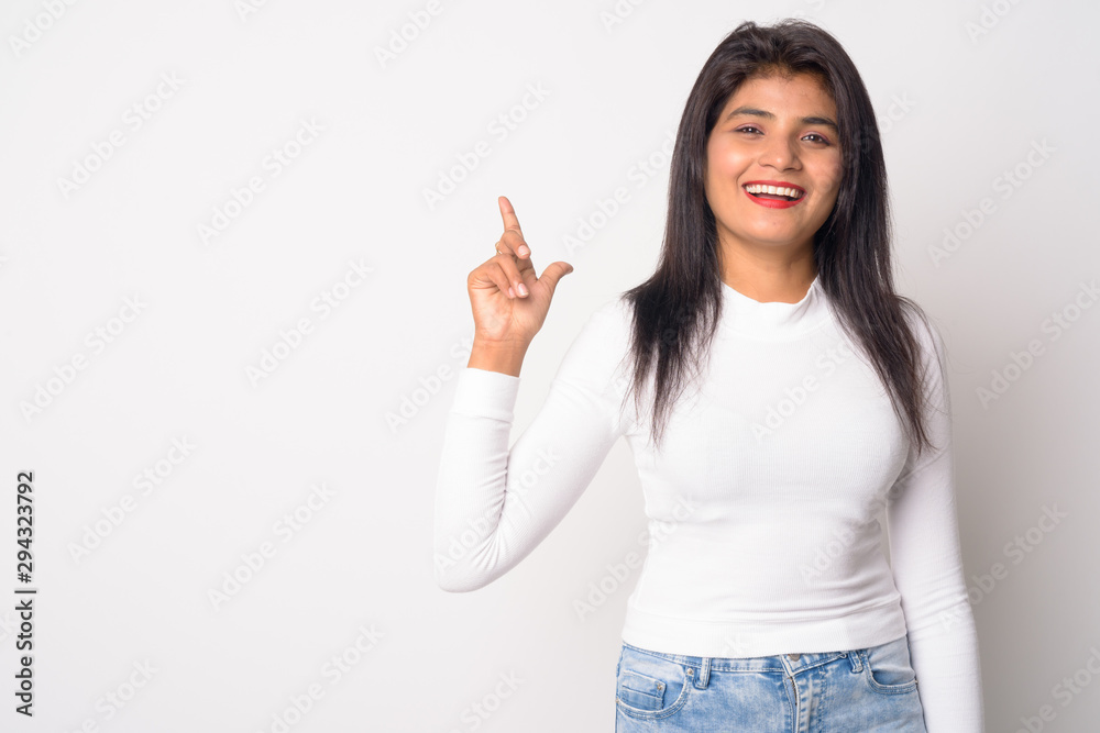 Happy young beautiful Persian woman pointing up Happy young beautiful Persian woman pointing up