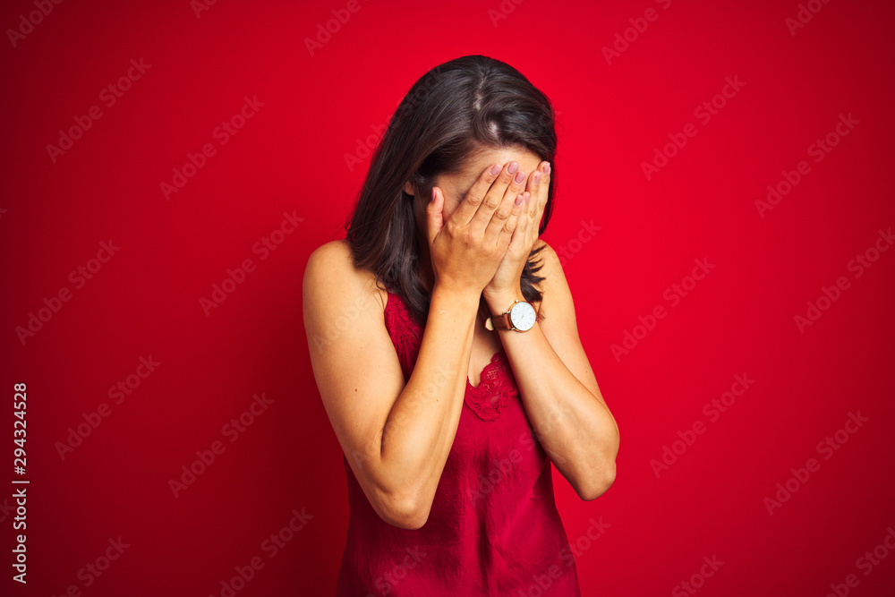 Young beautiful woman wearing sexy lingerie over red isolated background with sad expression covering face with hands while crying. Depression concept. Young beautiful woman wearing sexy lingerie over red isolated background with sad expression covering face with hands while crying. Depression concept.
