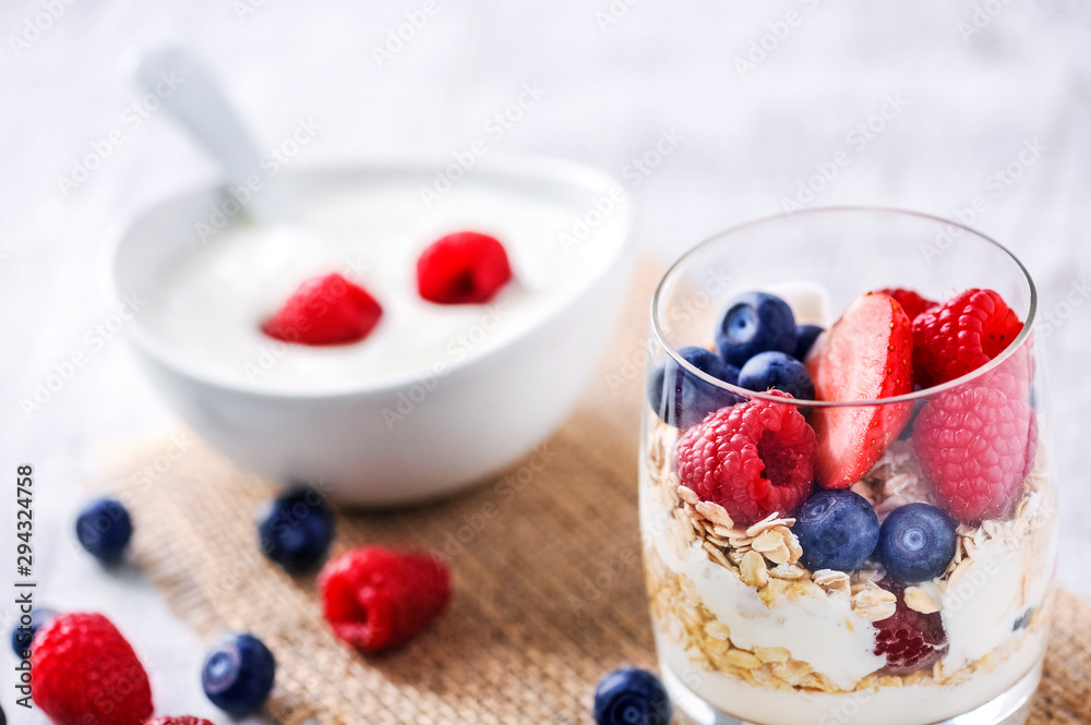 yogurt with forest fruits in white porcelain bowl. Yogurt with raspberries and blueberries. yogurt with forest fruits in white porcelain bowl. Yogurt with raspberries and blueberries.