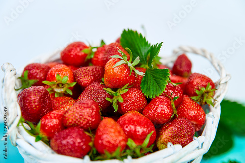 Ripe red strawberries on blue table, Strawberries in white basket. Fresh strawberries. Beautiful strawberries. Diet food. Healthy, vegan. Copy space.