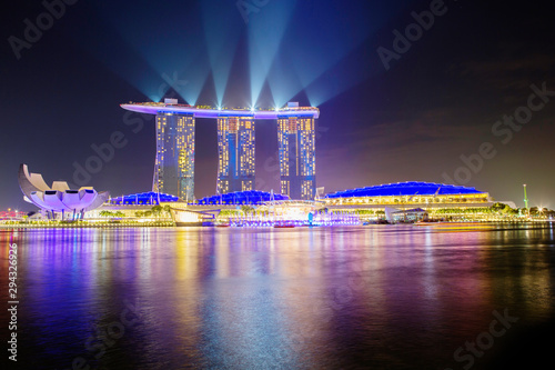 Singapore, Marina Bay Sands Hotel. Laser show at Marina Bay in the evening. The main attraction of the Bay is the hotel, consisting of three 55-storey towers, United on top of one huge observation de