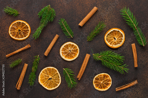christmas brown background with fir branches, dried oranges and cinnamon. Christmas, winter, new year concept. Flat lay, pattern, top vew.