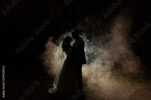 silhouette of a bride and groom with a smokey background