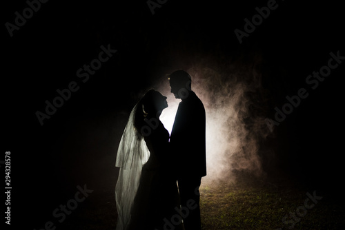 silhouette of a bride and groom with a smokey background