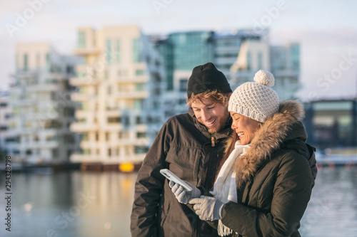 Photography Phone couple using mobile on winter city walk walking outside on street looking up directions on online app