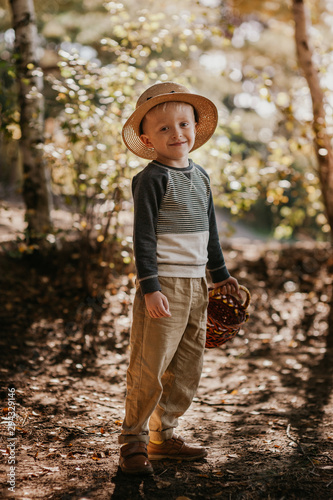 Stylish boy in a hat with a basket. boy in the park in a hat with a basket in autumn © andreiko