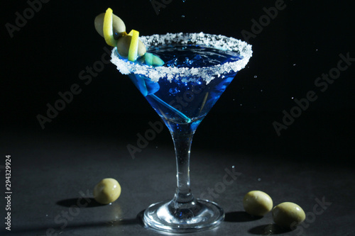 A glass with blue martini cocktail	