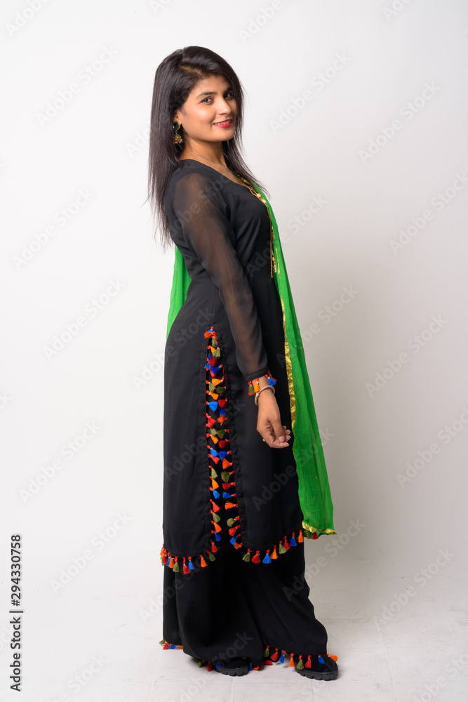 Full body shot of happy young Persian woman smiling in traditional clothing