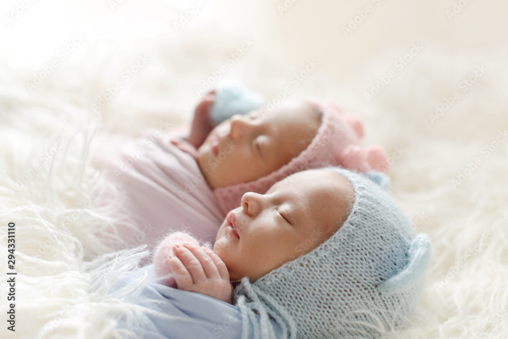 The sleeping Newborn gilr and boy lies on the white fur. Newborn twins The sleeping Newborn gilr and boy lies on the white fur. Newborn twins