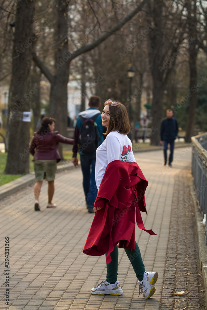 Walk in the autumn park one girl in purple coat. The view from the back. Walk in the autumn park one girl in purple coat. The view from the back.