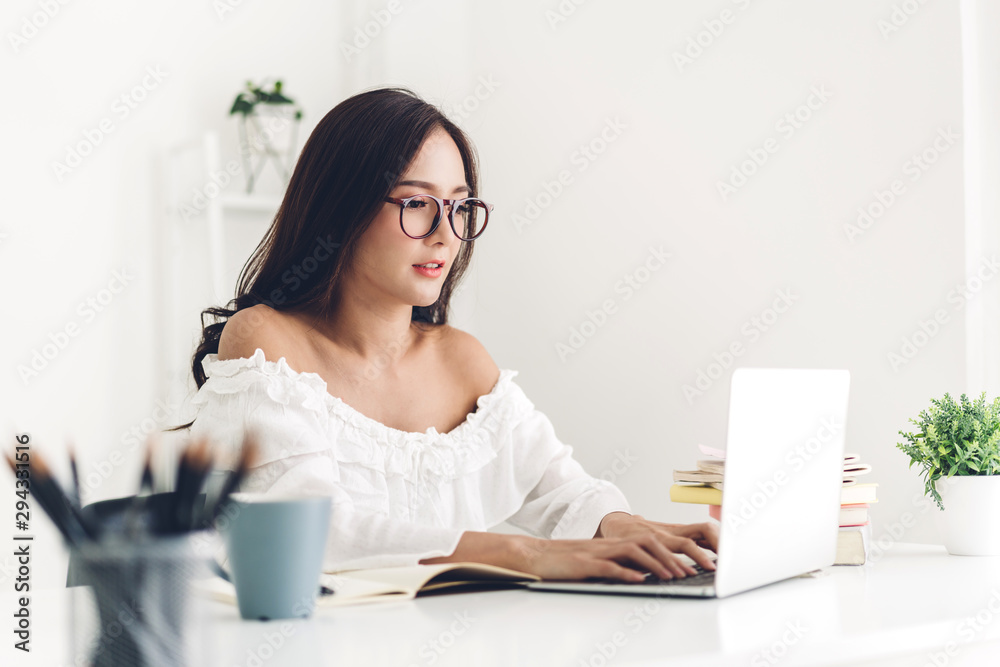 Girl student sitting and studying and learning online with laptop computer and reading a book before the exam at home.education concept Girl student sitting and studying and learning online with laptop computer and reading a book before the exam at home.education concept