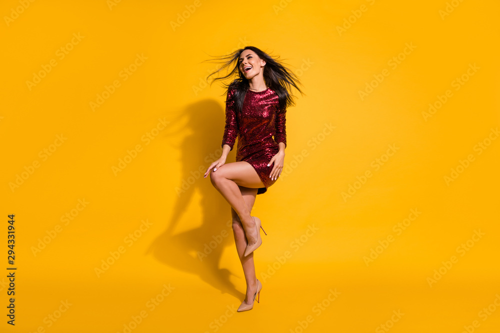 Full body photo of amazing lady with flying hairdo and perfect shapes dancing at disco party wear short shine red dress isolated yellow color background Full body photo of amazing lady with flying hairdo and perfect shapes dancing at disco party wear short shine red dress isolated yellow color background