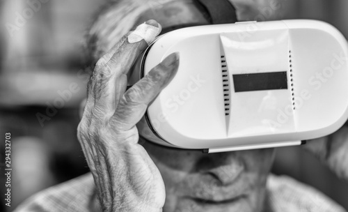 Face portrait of a elderly retired man using VR visor. Virtual reality experience