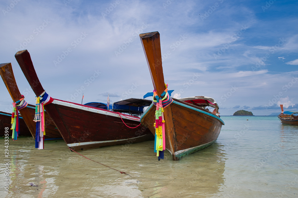 Boat or Taxi moored in The beach in Thailand on a summer day with sun and clouds. Also called Longtails. Boat or Taxi moored in The beach in Thailand on a summer day with sun and clouds. Also called Longtails.