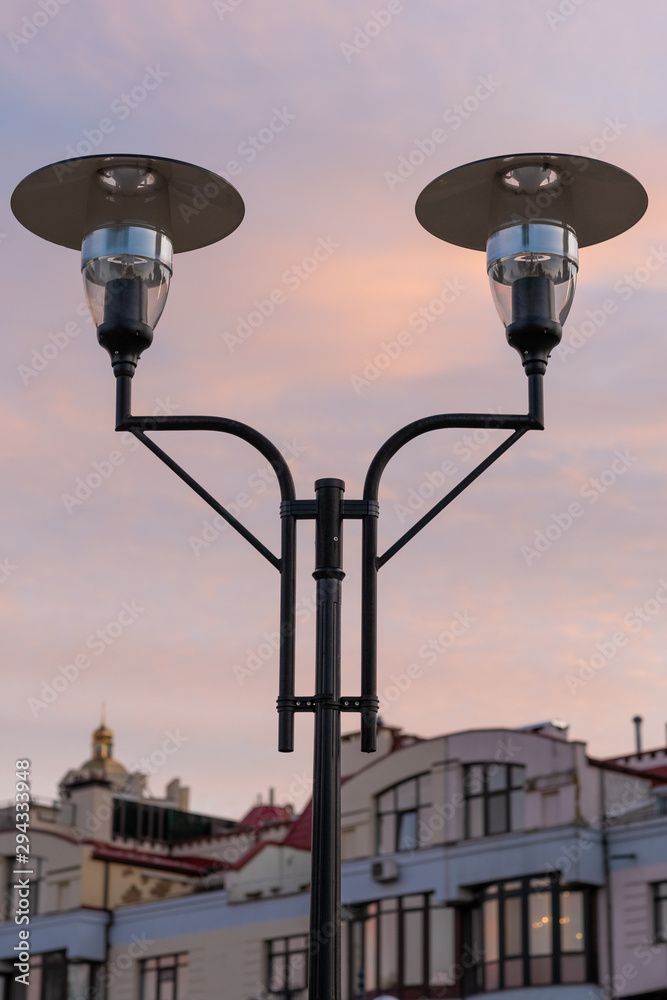 modern street lamps against the blue-red evening sky and dwelling house