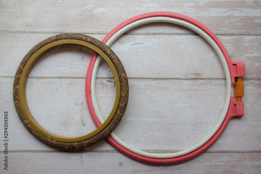 Two round frames in the center of a wooden background. Frames on the background. Embroidery hoop. copy space, top view, flat lay, background with blank space for text Two round frames in the center of a wooden background. Frames on the background. Embroidery hoop. copy space, top view, flat lay, background with blank space for text