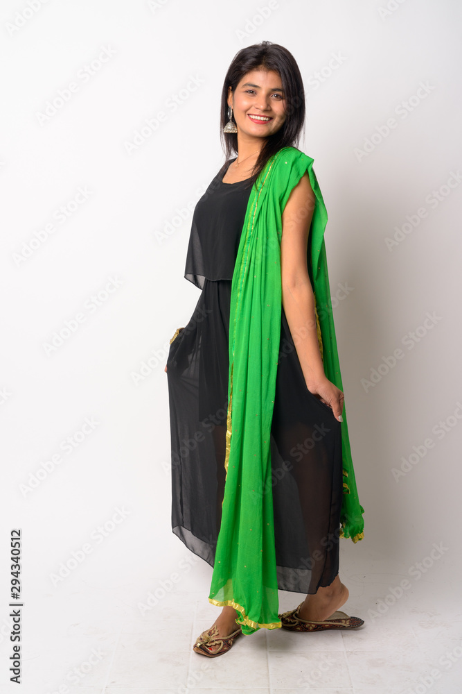 Full body shot of happy young Persian woman smiling in traditional clothing Full body shot of happy young Persian woman smiling in traditional clothing