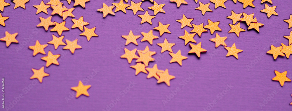 Golden stars glitter on lavender paper background Golden stars glitter on lavender paper background