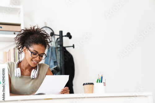 Pleased young african woman using laptop computer