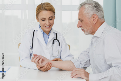 Doctor examining hand of patient